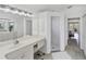 A bright main bathroom featuring a vanity with a sink, a shower, and access to the main bedroom at 56 Long Meadow Ct, Rotonda West, FL 33947