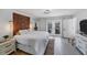 Bright main bedroom with a decorative headboard, patio access, and an ensuite bathroom at 56 Long Meadow Ct, Rotonda West, FL 33947