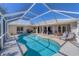 Private, screened pool with ample patio space, lounge seating, and meticulous landscaping at 56 Long Meadow Ct, Rotonda West, FL 33947