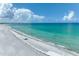 Expansive beach view with pristine white sand and clear turquoise water under a bright blue sky with scattered clouds at 5700 Gulf Shores Dr # A312, Boca Grande, FL 33921