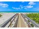 Beautiful beach access with a wooden walkway leading to the pristine white sands and blue ocean at 5700 Gulf Shores Dr # A312, Boca Grande, FL 33921
