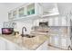 Modern kitchen with granite countertops, tile backsplash, white cabinets, and stainless steel appliances at 5700 Gulf Shores Dr # A312, Boca Grande, FL 33921