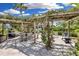 Outdoor dining area under a wooden pergola, complete with seating and barbecue grills for entertaining at 5700 Gulf Shores Dr # A312, Boca Grande, FL 33921
