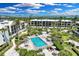 Aerial view of a community pool and hot tub surrounded by tropical landscaping near the beach at 5700 Gulf Shores Dr # A312, Boca Grande, FL 33921