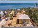 Breathtaking aerial view showcasing waterfront home, mature palms, and waterfront access at 6029 Manasota Key Rd, Englewood, FL 34223