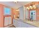 Bathroom featuring double sinks, granite counters, and a window for natural light at 6029 Manasota Key Rd, Englewood, FL 34223