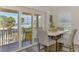 Bright dining area with modern table, chairs, and sliders to a water view balcony at 6029 Manasota Key Rd, Englewood, FL 34223