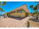 Charming front exterior featuring a unique roofline, brick pathway, and well-maintained landscaping at 6029 Manasota Key Rd, Englewood, FL 34223