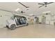 Spacious garage featuring epoxy flooring, ceiling fans, golf cart, washer, dryer and storage at 6029 Manasota Key Rd, Englewood, FL 34223