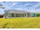 An expansive, green backyard surrounds a screened pool and lovely home exterior at 6062 Spinnaker Blvd, Englewood, FL 34224