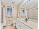 Bathroom featuring a shower-tub combo, white vanity and a large framed mirror at 6062 Spinnaker Blvd, Englewood, FL 34224