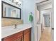 Bright bathroom featuring a dark vanity, medicine cabinet, and doorway leading to the laundry room at 6062 Spinnaker Blvd, Englewood, FL 34224