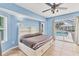 Light blue bedroom featuring a ceiling fan and direct access to the outdoor pool area at 6062 Spinnaker Blvd, Englewood, FL 34224