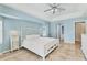Bright bedroom features stylish white furniture, blue walls and tan tile flooring at 6062 Spinnaker Blvd, Englewood, FL 34224