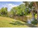 Picturesque canal with a dock surrounded by lush greenery and trees at 6062 Spinnaker Blvd, Englewood, FL 34224