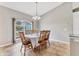 Bright dining room featuring a large arched window and seating for six at 6062 Spinnaker Blvd, Englewood, FL 34224