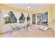 Bright sunroom with tile floors, a dining area with a view of the well-landscaped yard at 6062 Spinnaker Blvd, Englewood, FL 34224