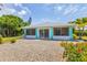 Enclosed sunroom with screened windows and sliding glass doors leading to gravel yard at 6062 Spinnaker Blvd, Englewood, FL 34224