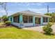 Enclosed sunroom with sliding glass doors offers seamless indoor-outdoor living with lush landscaping at 6062 Spinnaker Blvd, Englewood, FL 34224