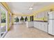 Bright sunroom kitchenette with white cabinets, tile flooring, and a dining area with garden views at 6062 Spinnaker Blvd, Englewood, FL 34224