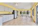 Bright sunroom kitchenette with white cabinets, tile flooring, and a dining area with garden views at 6062 Spinnaker Blvd, Englewood, FL 34224