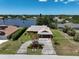 Aerial view of a single Gathering home with mature landscaping and a lake in the background, showing the circular drive at 6305 Shalimar St, Port Charlotte, FL 33981