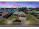 Aerial view of waterfront property features a well-maintained circular driveway, lush landscaping, and beautiful lake views at 6305 Shalimar St, Port Charlotte, FL 33981