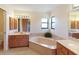 Spacious bathroom featuring a large tub, dual sinks and plenty of natural light at 6305 Shalimar St, Port Charlotte, FL 33981