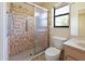 Bathroom featuring a vanity and toilet next to a glass door shower with brown tiles and a shower bar at 6305 Shalimar St, Port Charlotte, FL 33981