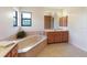 Well-lit bathroom featuring a soaking tub, large vanity, and tile floors at 6305 Shalimar St, Port Charlotte, FL 33981