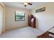Bright bedroom featuring a large window overlooking trees with an antique desk and cabinet against the wall at 6305 Shalimar St, Port Charlotte, FL 33981