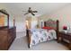 Bedroom with a ceiling fan, decorative headboard, and view to a bathroom down a hall at 6305 Shalimar St, Port Charlotte, FL 33981
