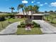 Charming exterior view features a well-maintained circular driveway with mature landscaping and a spacious two-car garage at 6305 Shalimar St, Port Charlotte, FL 33981