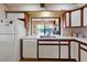 Kitchen with white appliances, countertops, and ample cabinet space, sink view at 6305 Shalimar St, Port Charlotte, FL 33981