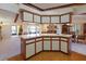 Kitchen island with white countertops, white and brown cabinetry, and seating at 6305 Shalimar St, Port Charlotte, FL 33981