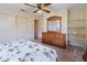 Bright bedroom featuring a ceiling fan, closet, dresser with mirror, shelves and a bed with a palm tree themed cover at 6305 Shalimar St, Port Charlotte, FL 33981