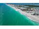 Expansive aerial view of a beautiful coastline with clear turquoise water and beachfront properties along the shore at 667 Foxwood Blvd, Englewood, FL 34223