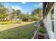 Backyard featuring well-maintained lawn, mature trees and landscaping at 667 Foxwood Blvd, Englewood, FL 34223