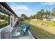 Backyard featuring well-maintained lawn and patio with seating and mature trees at 667 Foxwood Blvd, Englewood, FL 34223