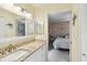Bright bathroom with granite countertops, white cabinetry, and view to main bedroom at 667 Foxwood Blvd, Englewood, FL 34223