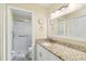 Bright bathroom with granite countertops, white cabinetry, and glass-enclosed shower at 667 Foxwood Blvd, Englewood, FL 34223