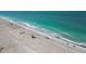 Aerial view of a vibrant beach with clear turquoise water and scattered beachgoers enjoying the sunny day at 667 Foxwood Blvd, Englewood, FL 34223