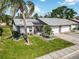 Well-maintained home with a gray roof, lush landscaping, and a welcoming screened entryway at 667 Foxwood Blvd, Englewood, FL 34223