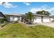 Well-maintained single-story home featuring a lush green lawn, an attached garage, and attractive landscaping at 667 Foxwood Blvd, Englewood, FL 34223