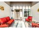 Inviting front porch with comfortable red furniture and nautical decor, perfect for relaxation and enjoying the outdoors at 667 Foxwood Blvd, Englewood, FL 34223