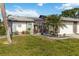 Charming home showcasing manicured lawn, a decorative pergola, lush landscaping, and an inviting entrance at 667 Foxwood Blvd, Englewood, FL 34223