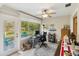 Bright office space with round rug and large windows looking out at the outdoor backyard area at 667 Foxwood Blvd, Englewood, FL 34223