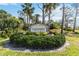 Welcoming Foxwood community sign surrounded by lush landscaping and palm trees at 667 Foxwood Blvd, Englewood, FL 34223
