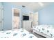 A bedroom with light blue walls, a closet, and a TV on top of a chest of drawers at 6800 Placida Rd # 262, Englewood, FL 34224