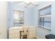 Bedroom featuring a desk with drawers, two windows, and a light blue accent wall at 6800 Placida Rd # 262, Englewood, FL 34224